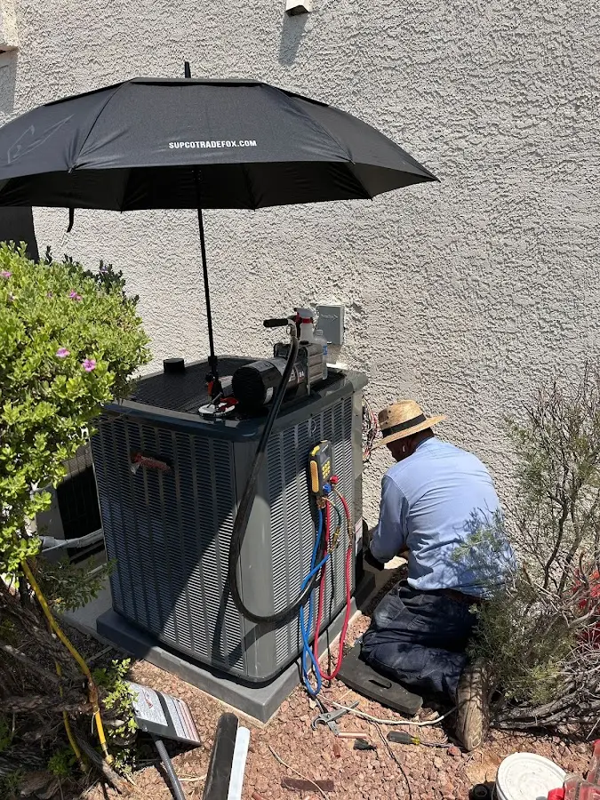 HVAC technician performing outdoor AC maintenance in Rutland